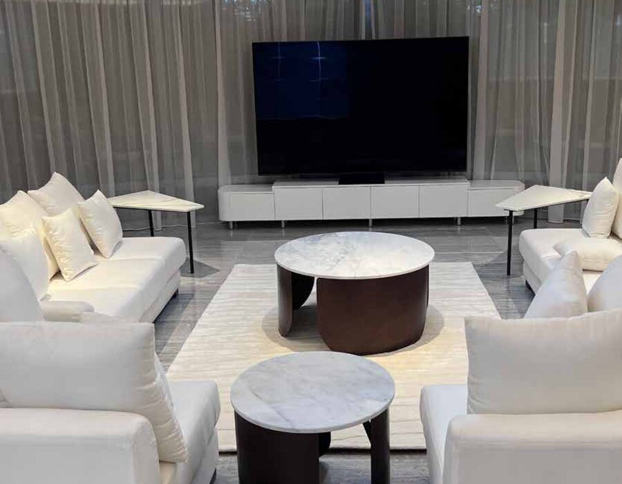 Finished living room of a Burj Khalifa apartment fitted out by 238Creative: cream sofas, marble tables and a wall-mounted television behind sheer curtains