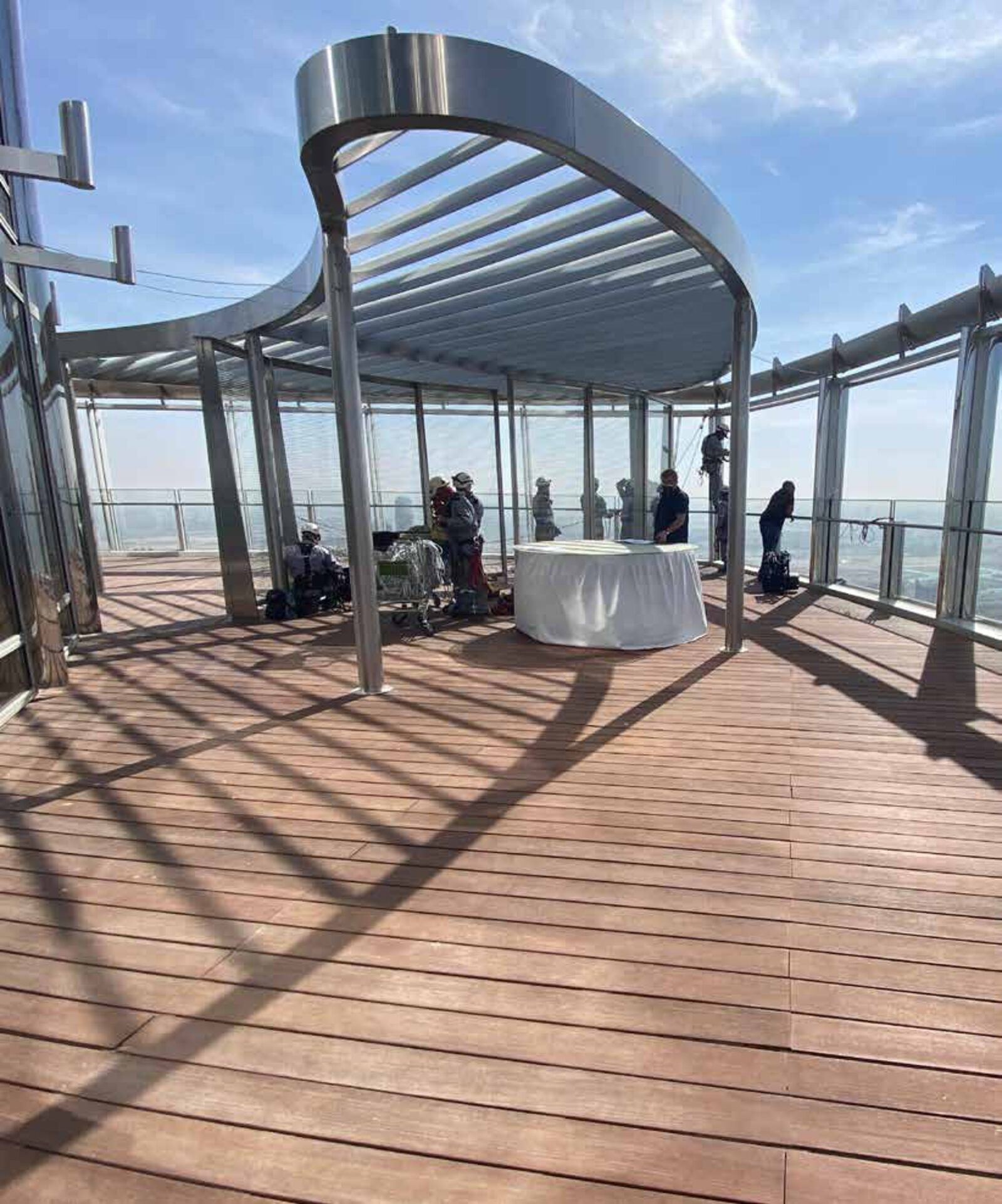 238Creative team on the terrace of a Burj Khalifa residence project, under a curved steel canopy above Dubai