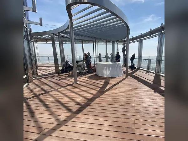 Terrace with a curved steel canopy and timber decking high above Dubai