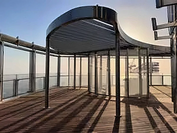 Curved steel pergola on the terrace under a blue sky