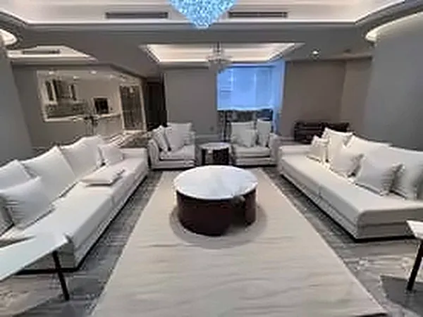 Spacious living room with cream sofas and a chandelier