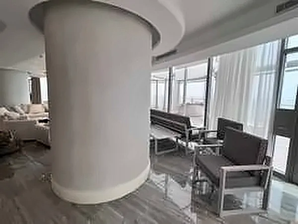 Open-plan living area with round columns and floor-to-ceiling windows