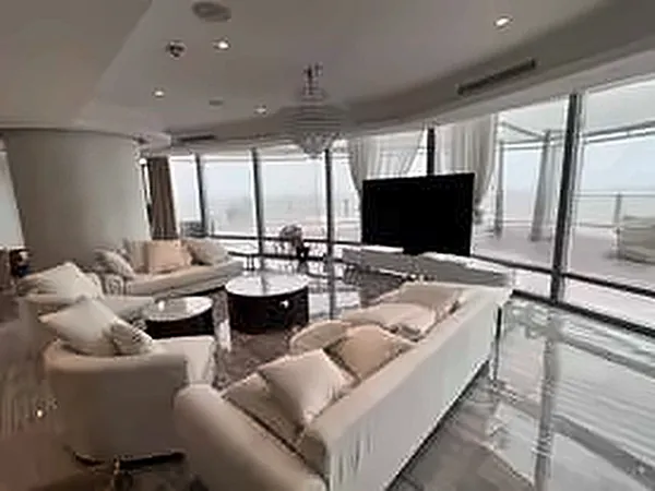 Lounge with cream sofas and a wall-mounted television