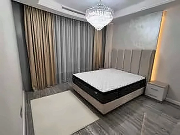 Bedroom with a bed, curtains and a chandelier