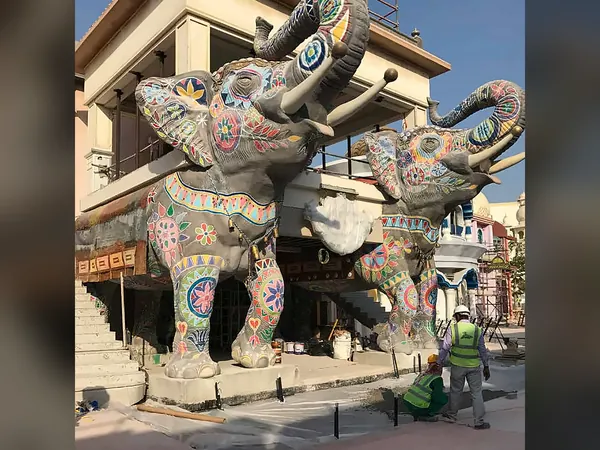 Painted elephant statues rising over an ornate themed entrance