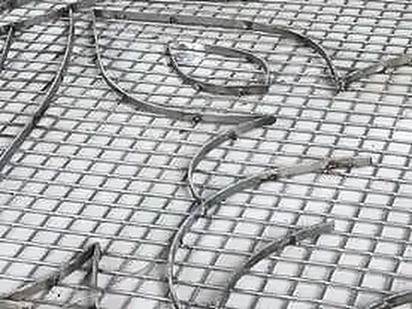 Close-up of mosaic tile with metal inlay pattern being laid