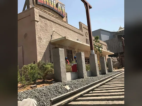 Themed street with railway tracks and stone-clad buildings
