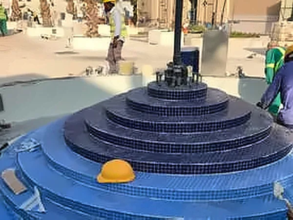Blue-tiled stepped circular feature under construction
