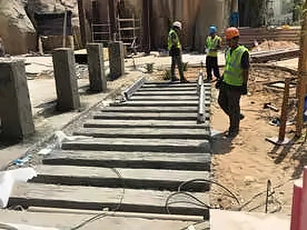 Railway sleepers being laid between stone walls