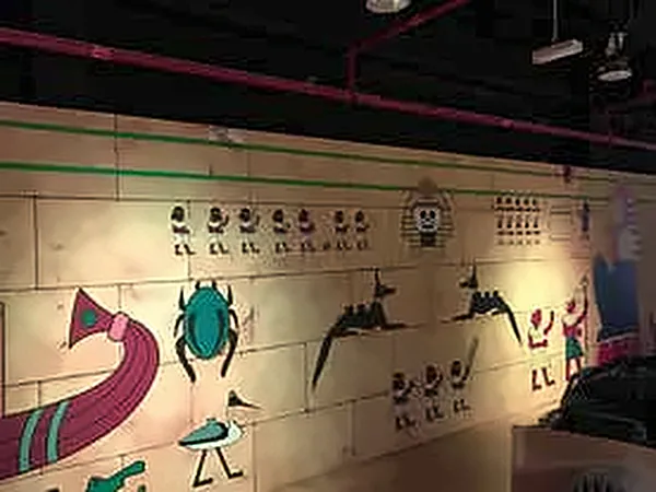 Hieroglyph-style painted wall with scarab and bird motifs