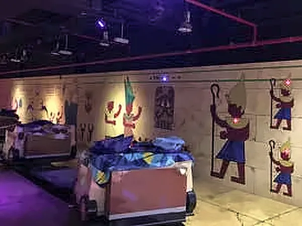 Themed room lit in purple with painted wall panels and vehicles