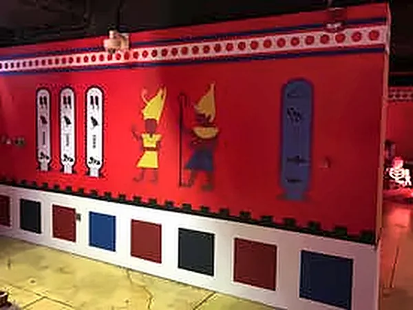 Red wall with hieroglyph panels above a golden floor