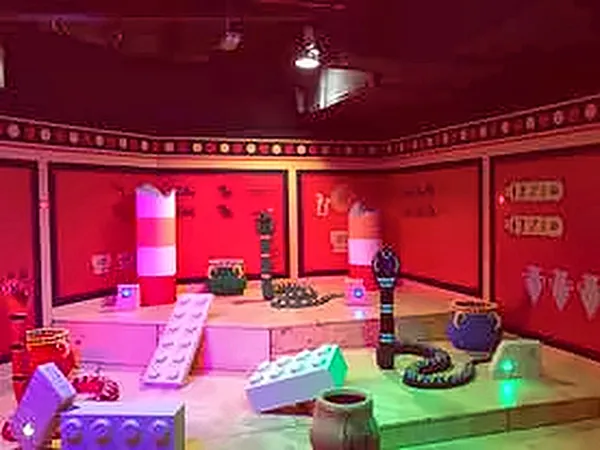 Pink and red lit themed room with building-block props
