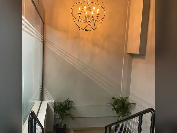Hallway with a spherical chandelier and potted plants
