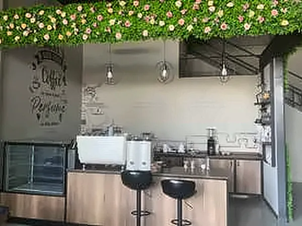 Café counter beneath a hanging floral ceiling