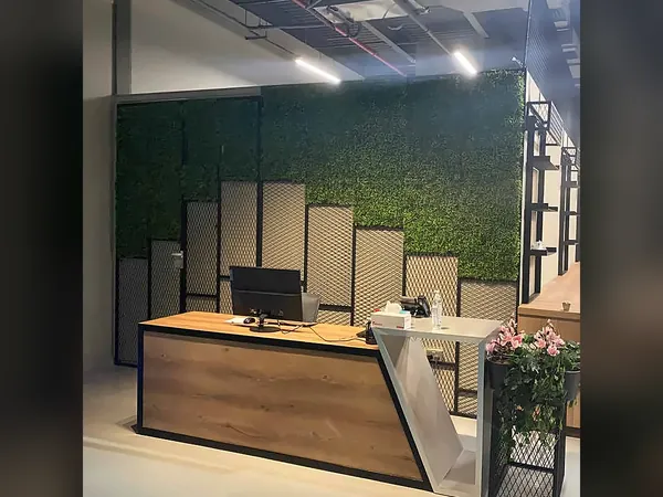 Reception desk in front of green living-wall panels