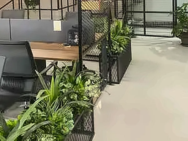 Staircase with a black steel railing and plants