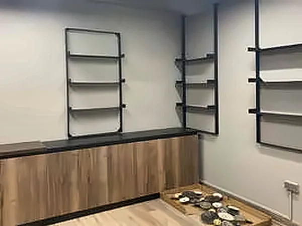 Timber cabinet and black steel shelving in a finished room
